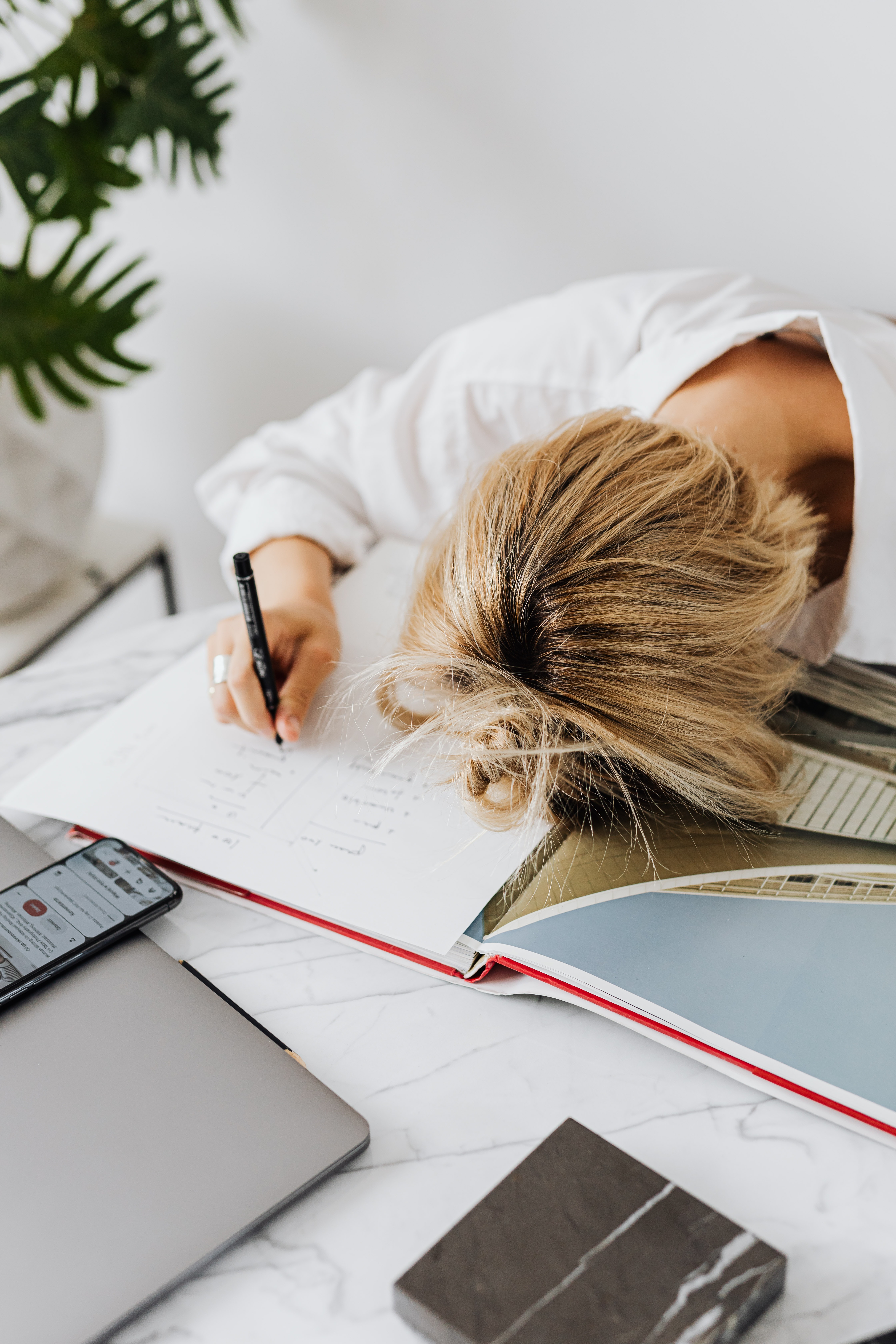 Overwhelmed woman with head on her desk