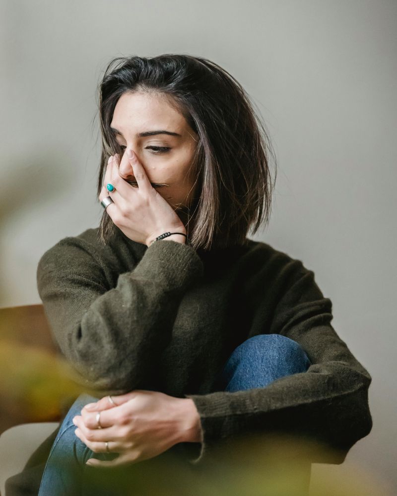 grieving woman covering her face with hand