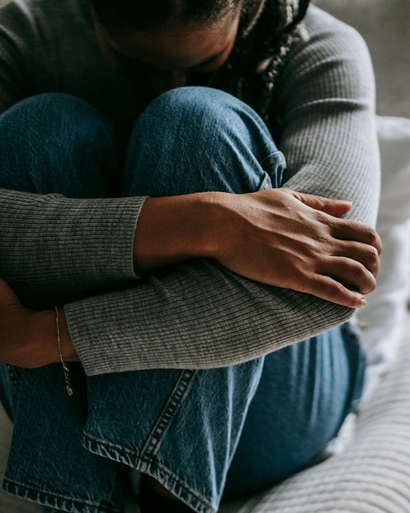 grieving woman sitting on a bed